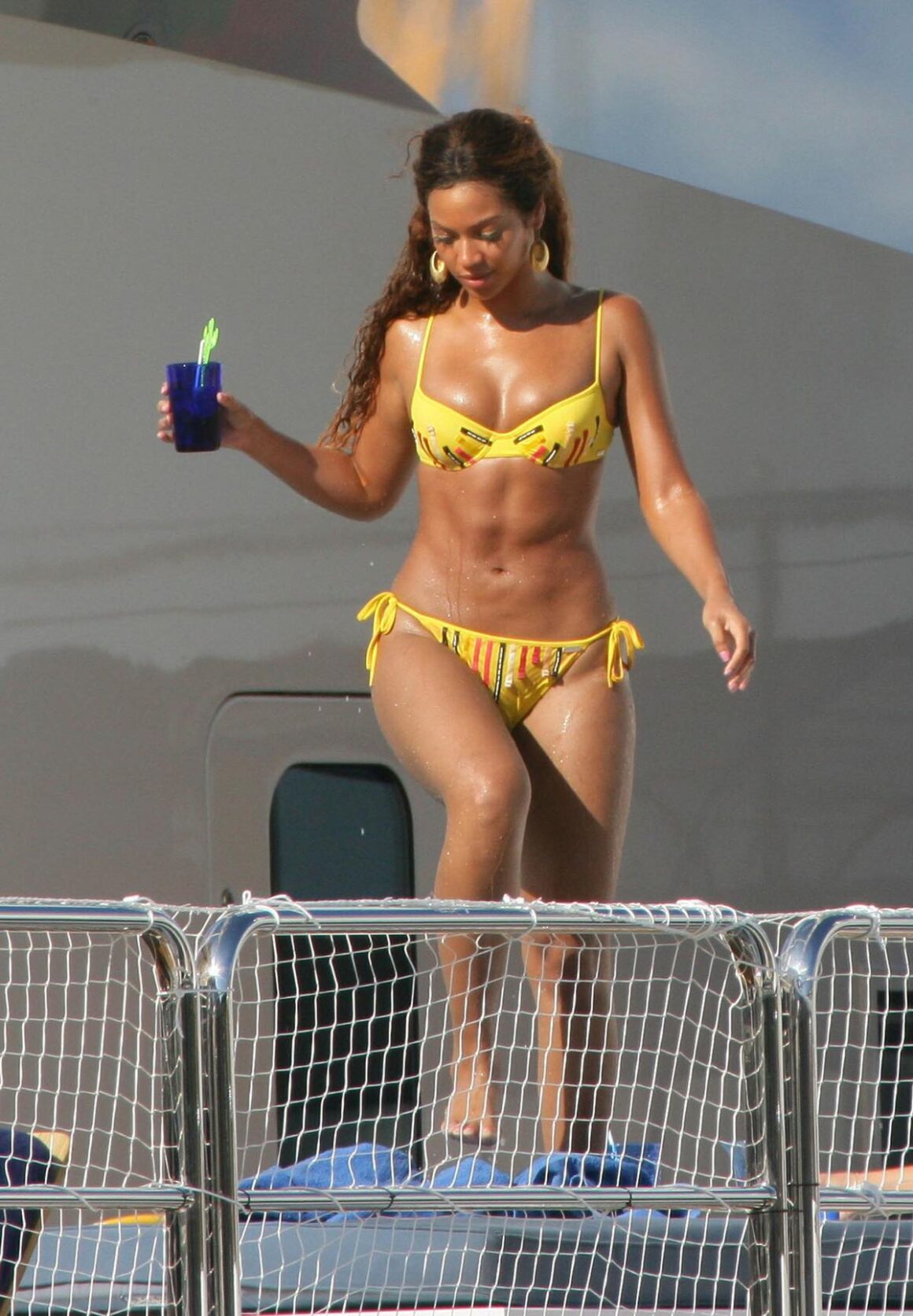 Beyonce Knowles shows off her toned body in a bright yellow bikini. 